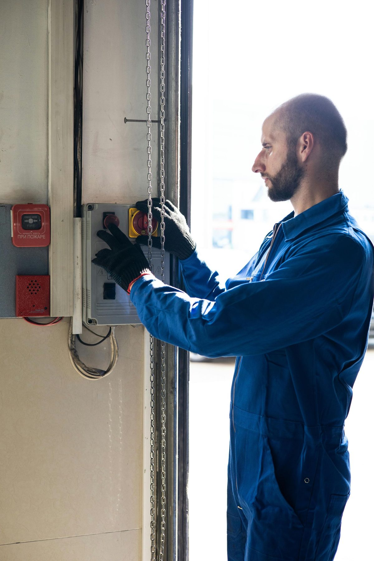 Electrician working inside an open wiring panel.